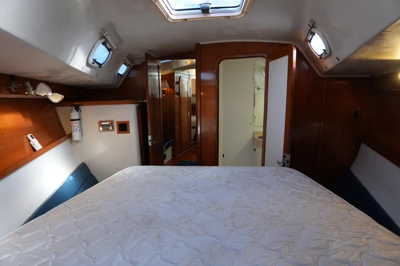 Slide: The Image of Interior cabin of 2002 Catalina 42 Mark II sailboat, featuring a cozy bed and wooden accents. - 14