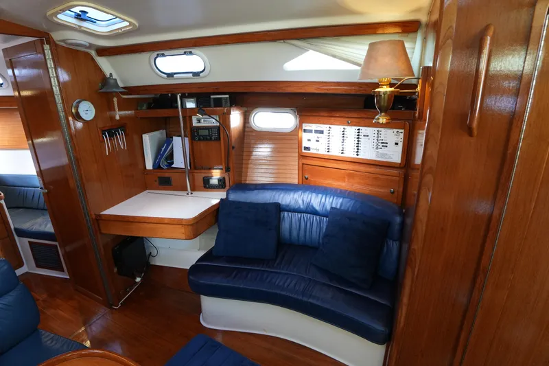 Slide: The Image of Interior of 2002 Catalina 42 Mark II sailboat with wood paneling and blue seating. - 18