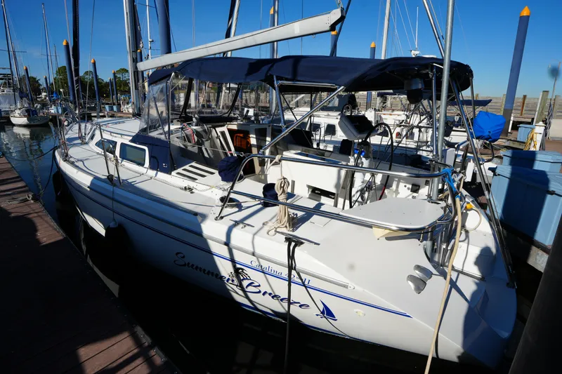Slide: The Image of 2002 Catalina 42 Mark II sailboat docked at marina under clear blue sky. - 2