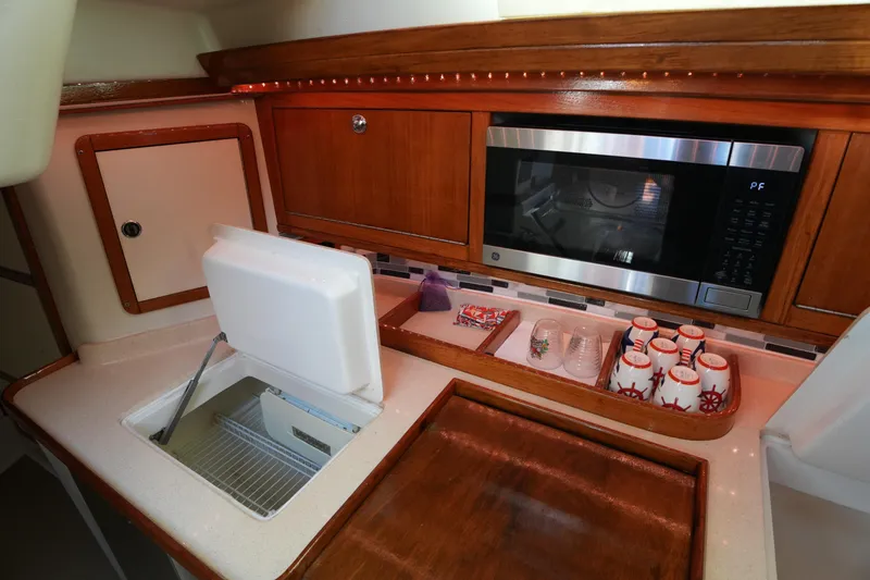 Slide: The Image of 2002 Catalina 42 Mark II yacht kitchen with microwave, sink, and storage. - 23