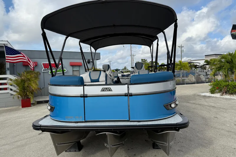 Slide: The Image of 2026 Avalon 2385 Catalina Quad Lounger, blue tri-toon boat with canopy, parked outdoors. - 3