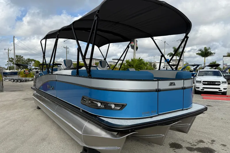 Slide: The Image of 2026 Avalon 2385 Catalina Quad Lounger, blue tri-toon boat with canopy, parked outdoors. - 4