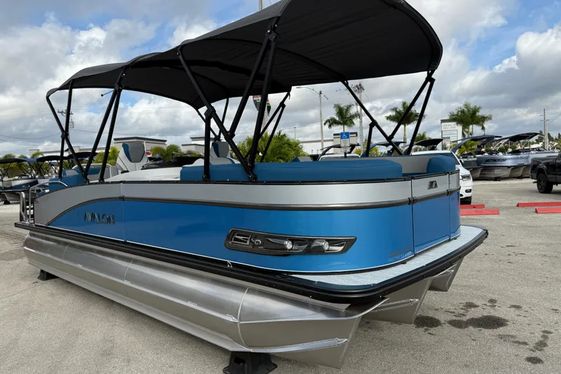 Slide: The Image of 2026 Avalon 2385 Catalina Quad Lounger, blue tri-toon boat with canopy, parked outdoors. - 5