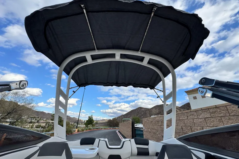 Slide: The Image of 2021 Yamaha Boats 195S with canopy, scenic mountain backdrop, and partly cloudy sky. - 10