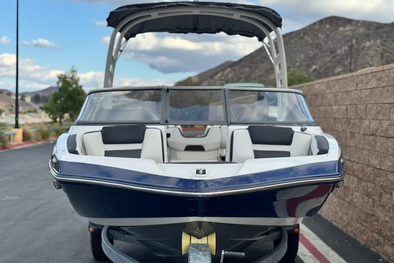 Slide: The Image of 2021 Yamaha Boats 195S on trailer, parked with scenic mountain backdrop. - 2