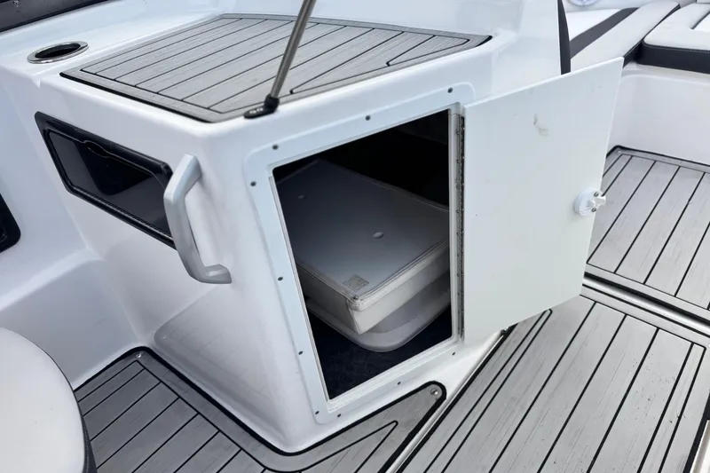 Slide: The Image of 2021 Yamaha Boats 195S storage compartment with open door, showcasing interior space. - 22