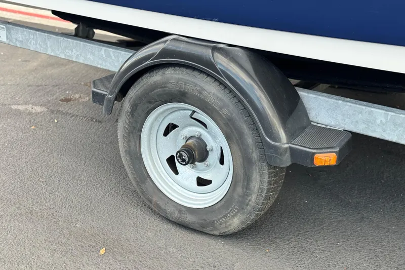 Slide: The Image of Trailer wheel of 2021 Yamaha Boats 195S, featuring a sturdy tire and fender. - 29