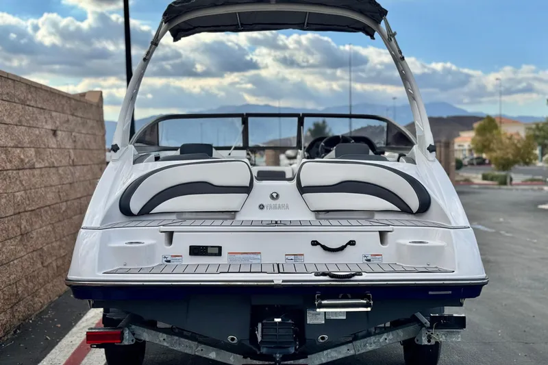 Slide: The Image of 2021 Yamaha Boats 195S, rear view, parked outdoors under cloudy sky. - 4