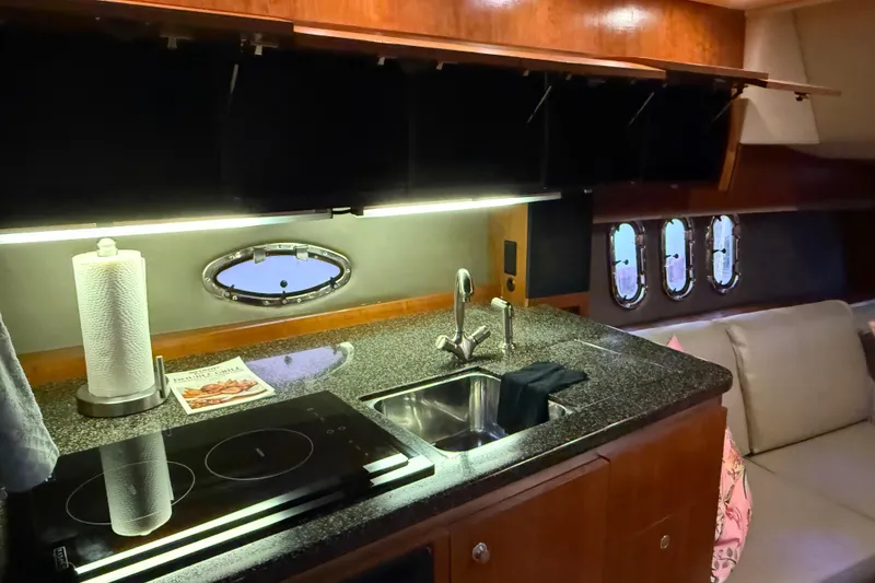Slide: The Image of 2005 Cruisers Yachts 420 Express interior kitchen with granite countertop and modern appliances. - 22