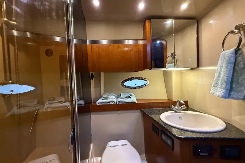 Slide: The Image of Luxurious bathroom in 2005 Cruisers Yachts 420 Express with modern fixtures and elegant wood cabinetry. - 23