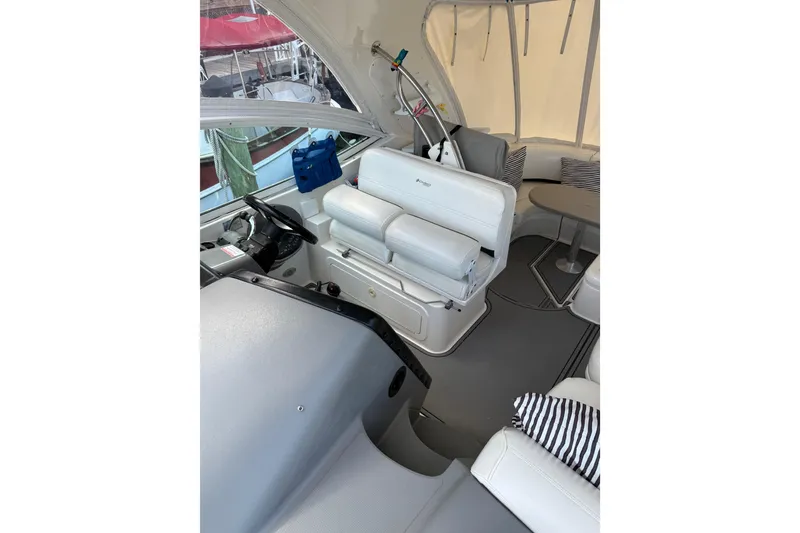 Slide: The Image of 2005 Cruisers Yachts 420 Express interior with helm, seating, and striped cushions. - 6