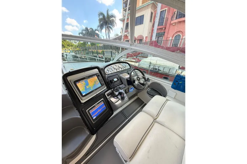 Slide: The Image of 2005 Cruisers Yachts 420 Express helm with navigation screens and steering wheel. - 9