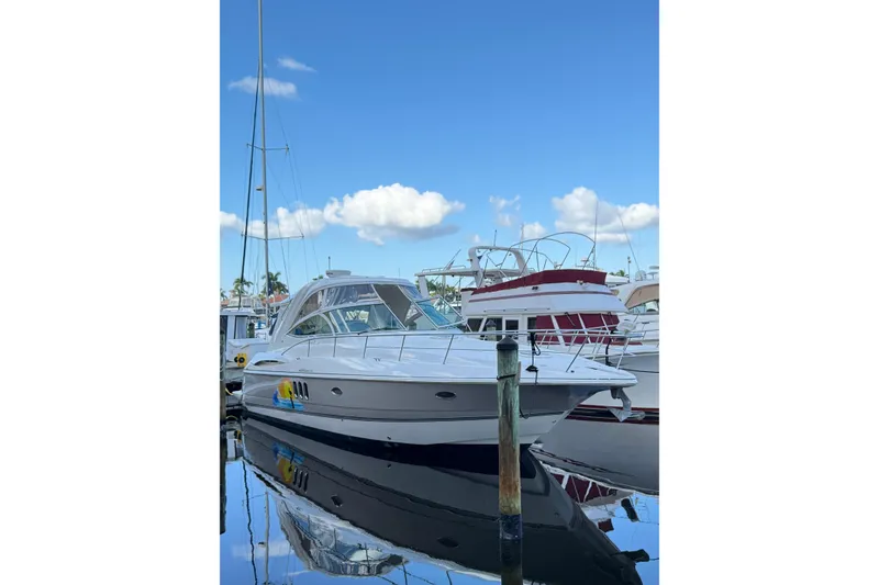 The Image of 2005 Cruisers Yachts 420 Express docked at marina under clear blue sky. - 1