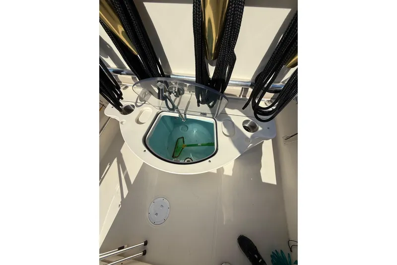 Slide: The Image of 2008 Pursuit C 250 Center Console boat interior with fishing rod holders and livewell. - 14