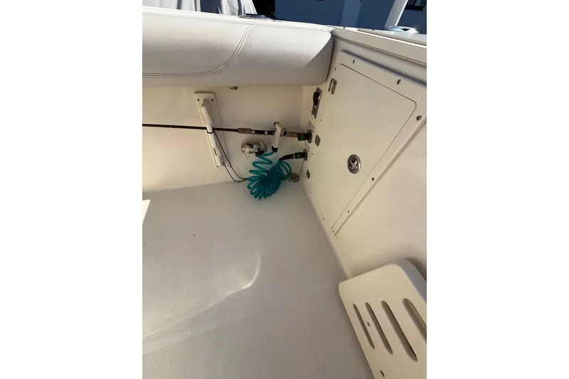 Slide: The Image of 2008 Pursuit C 250 Center Console interior with storage compartment and coiled hose. - 18