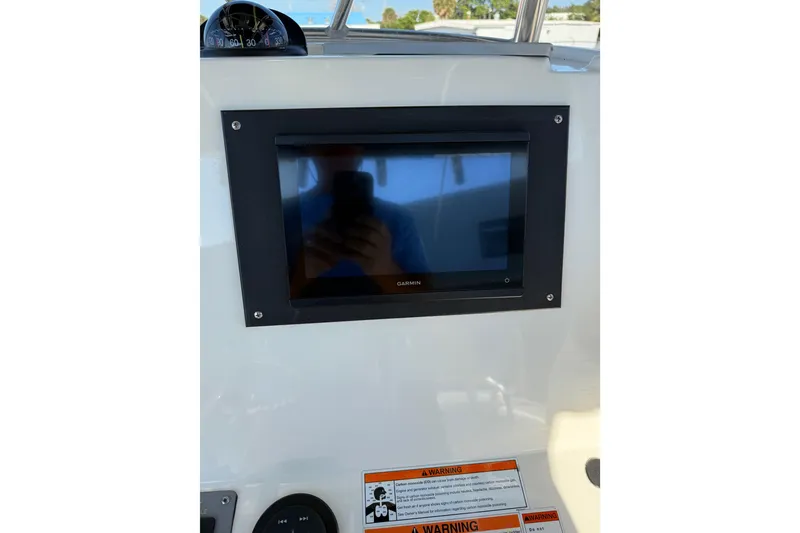 Slide: The Image of 2008 Pursuit C 250 Center Console dashboard with Garmin display and warning labels. - 32