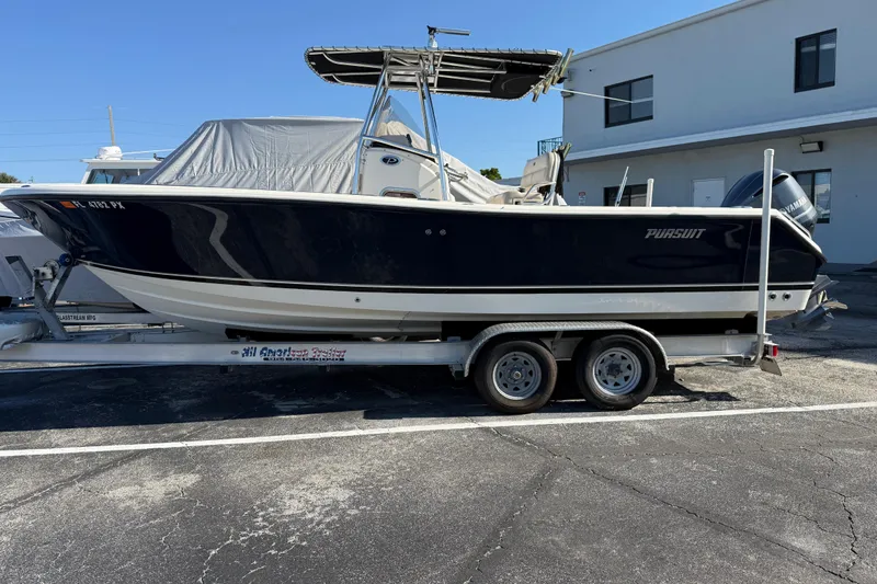 Slide: The Image of 2008 Pursuit C 250 Center Console boat on trailer, parked outdoors. - 4