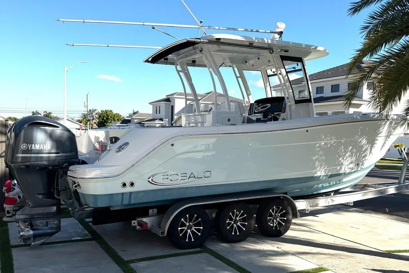 The Image of 2017 Robalo R302 Center Console boat on trailer with Yamaha engine, parked in residential area. - 1