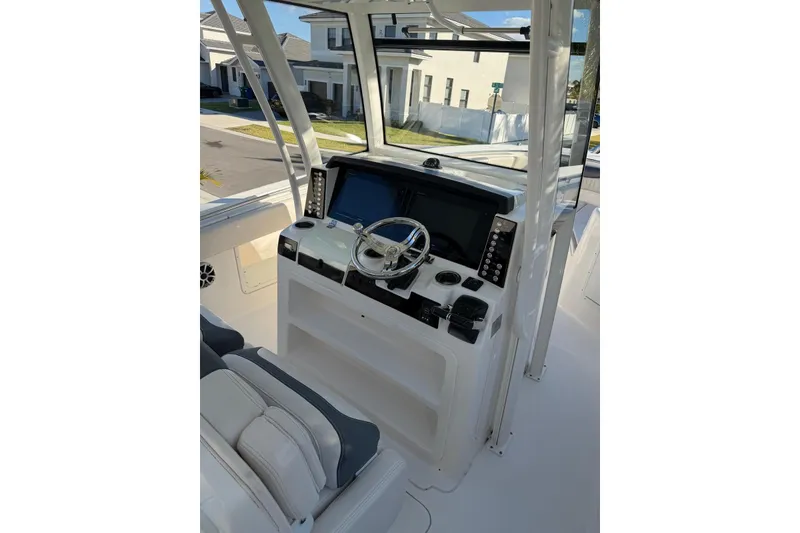 Slide: The Image of 2017 Robalo R302 Center Console boat interior with steering wheel and navigation controls. - 14