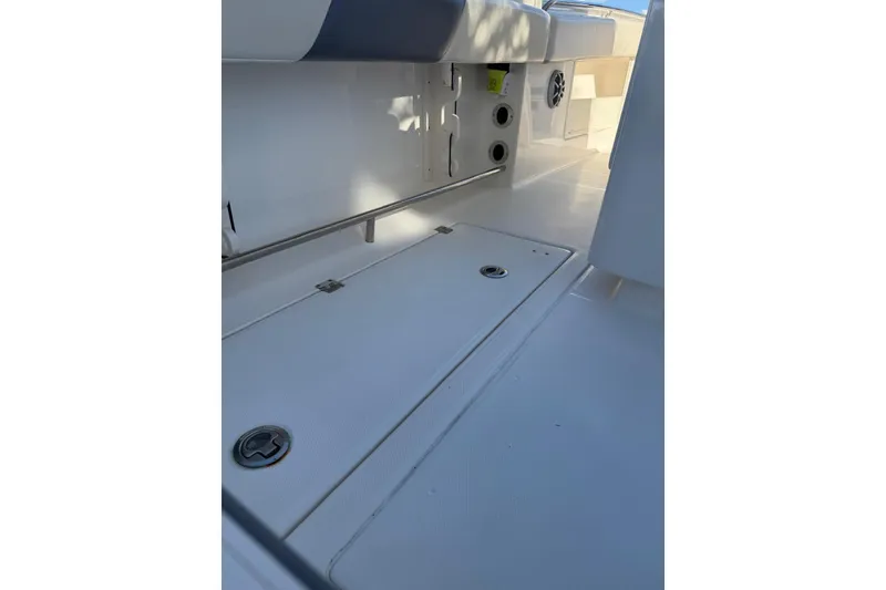 Slide: The Image of 2017 Robalo R302 Center Console boat interior, featuring storage compartments and seating area. - 16