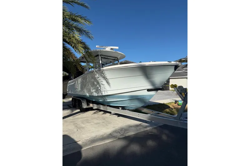 Slide: The Image of 2017 Robalo R302 Center Console boat on trailer under clear blue sky. - 3