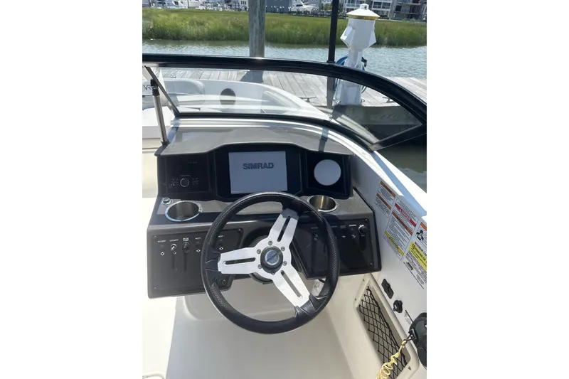 Slide: The Image of 2023 Bayliner VR6 Bowrider OB dashboard with steering wheel and Simrad display. - 3