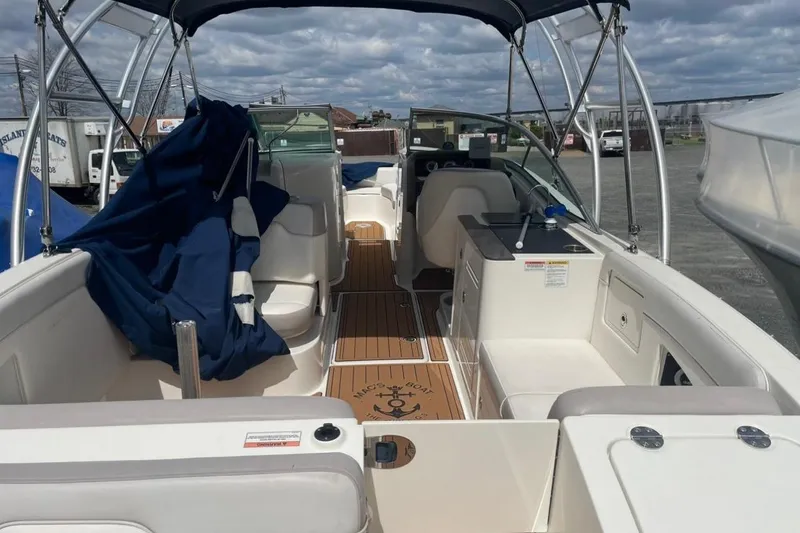 Slide: The Image of 2012 Sea Ray 300 Sundeck boat interior with seating and canopy, docked outdoors. - 6