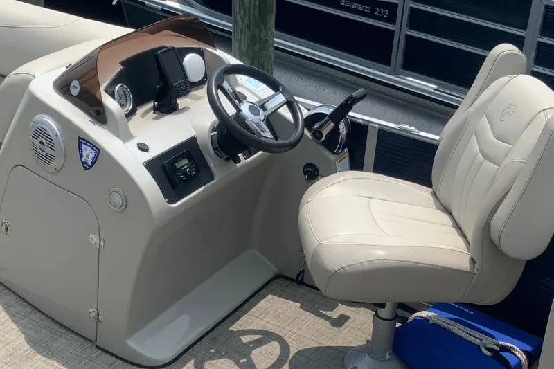 Slide: The Image of 2023 Cypress Cay Seabreeze 232 boat helm with beige captain's chair and control panel. - 4