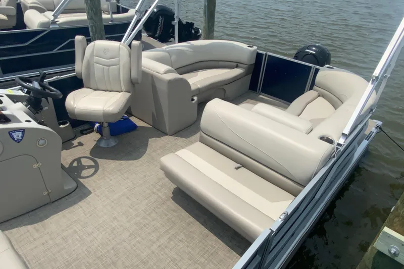 Slide: The Image of 2023 Cypress Cay Seabreeze 232 pontoon boat with beige seating on the water. - 6
