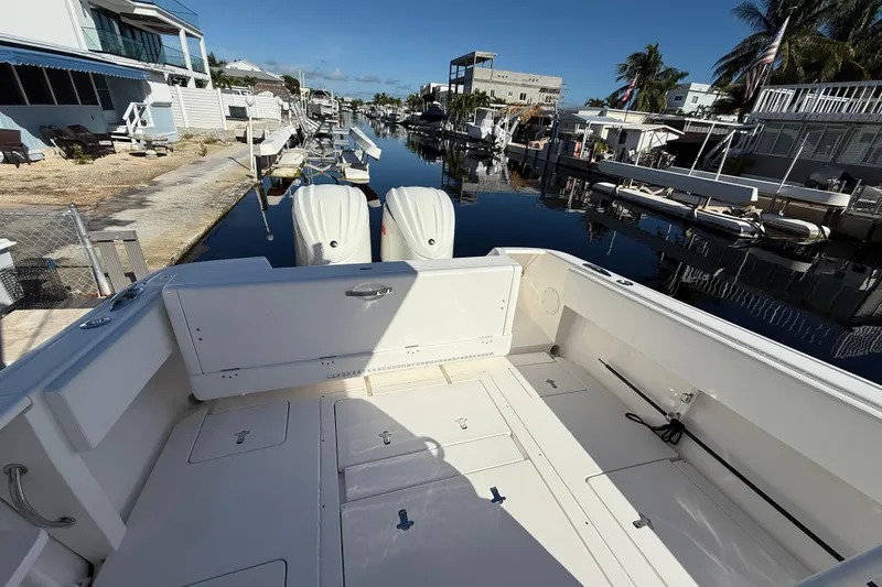 Slide: The Image of 2014 Intrepid 327 Center Console boat docked in a residential canal. - 10