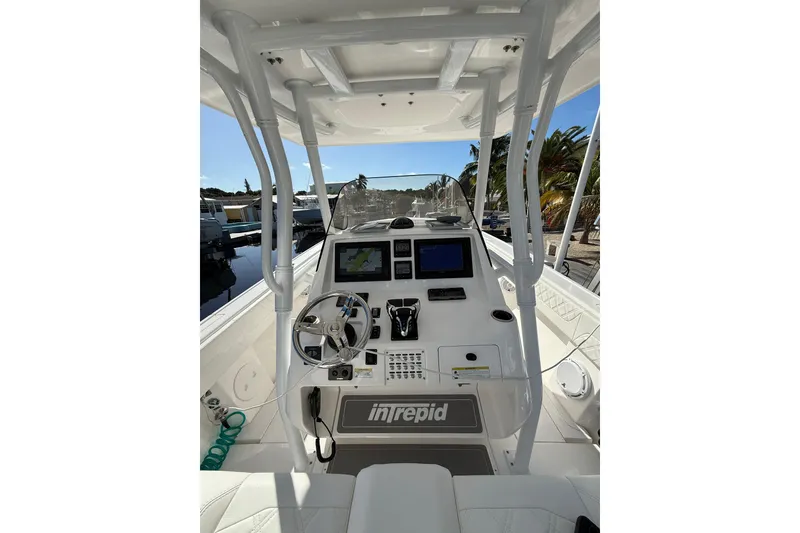 Slide: The Image of 2014 Intrepid 327 Center Console boat cockpit with steering wheel and navigation screens. - 14