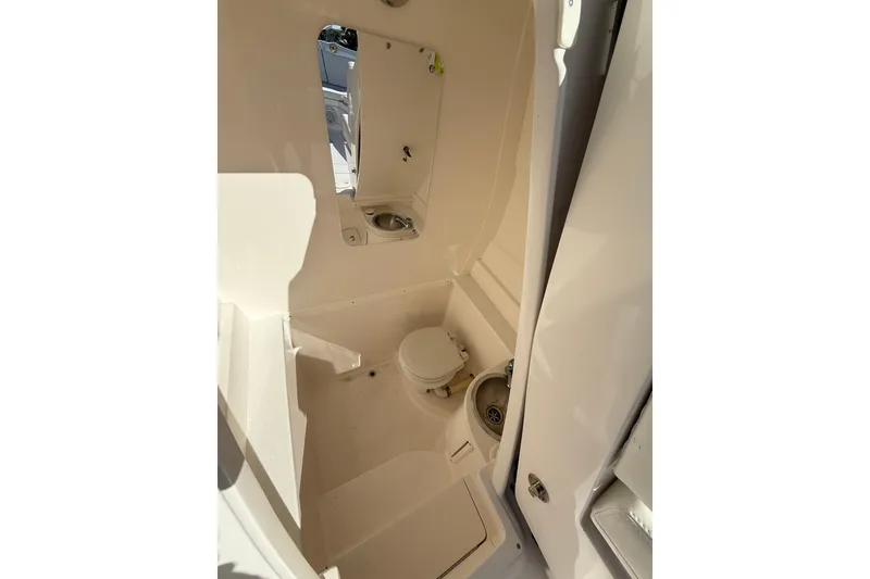 Slide: The Image of 2014 Intrepid 327 Center Console boat interior with toilet and sink. - 18