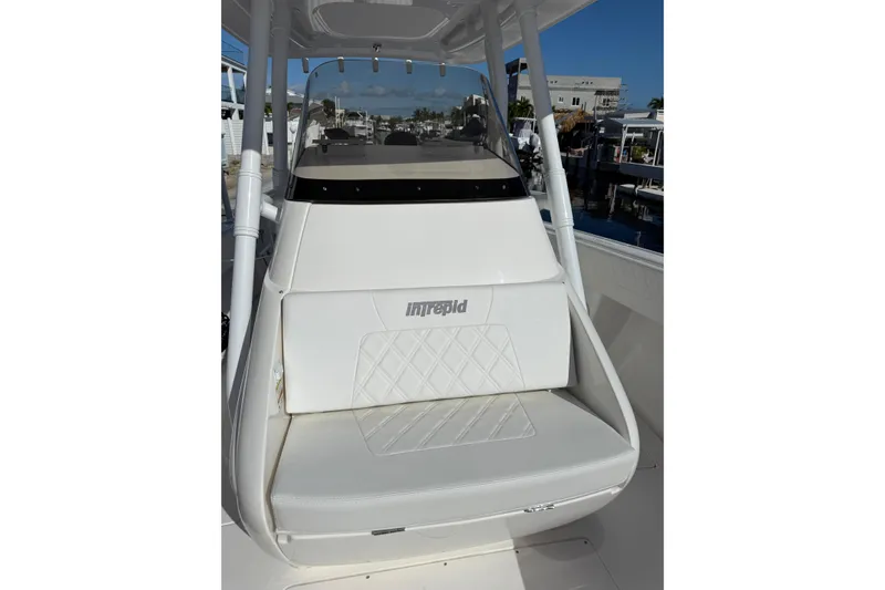 Slide: The Image of 2014 Intrepid 327 Center Console boat with white seating and console, docked at marina. - 20