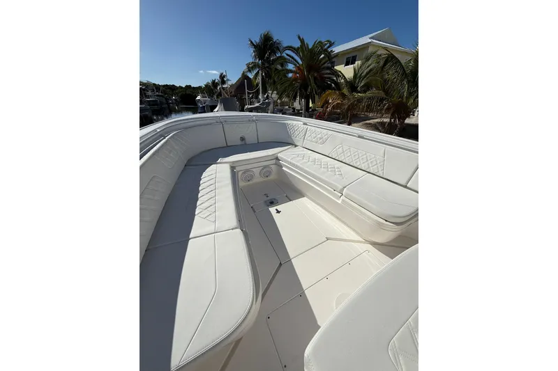 Slide: The Image of 2014 Intrepid 327 Center Console boat with white seating and tropical background. - 21