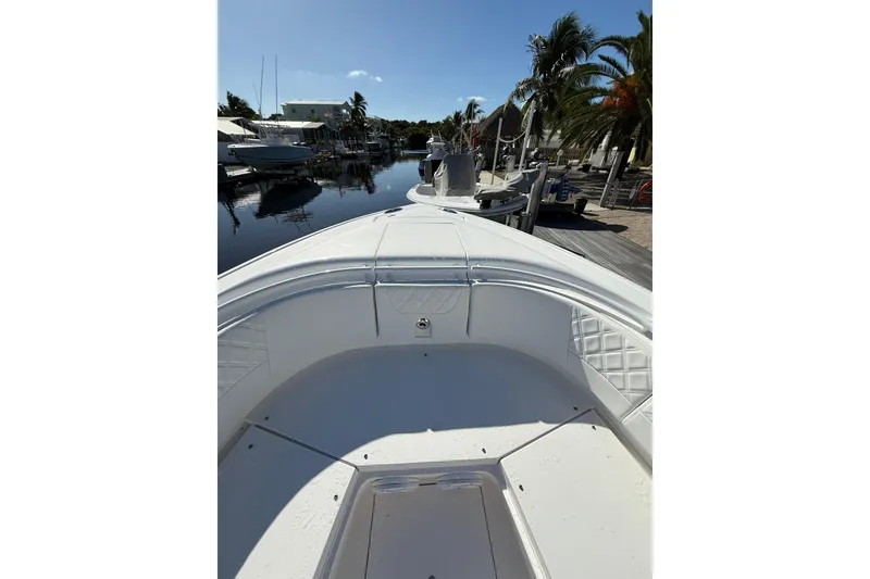 Slide: The Image of 2014 Intrepid 327 Center Console boat docked near palm trees and waterfront homes. - 22