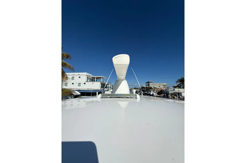 Slide: The Image of 2014 Intrepid 327 Center Console boat with radar, docked near waterfront homes. - 23