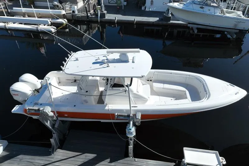 Slide: The Image of 2014 Intrepid 327 Center Console boat docked, featuring sleek design and dual engines. - 3