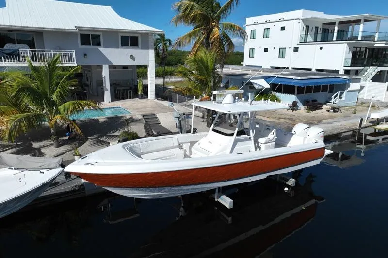 Slide: The Image of 2014 Intrepid 327 Center Console boat docked near waterfront homes. - 5