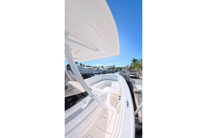 Slide: The Image of 2014 Intrepid 327 Center Console boat docked under clear blue sky. - 8