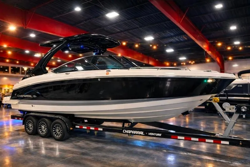 The Image of 2023 Chaparral 30 Surf boat on trailer in showroom with red beams. - 0