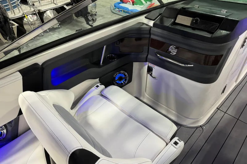 Slide: The Image of 2023 Chaparral 30 Surf boat interior with white seating and blue LED lighting. - 12