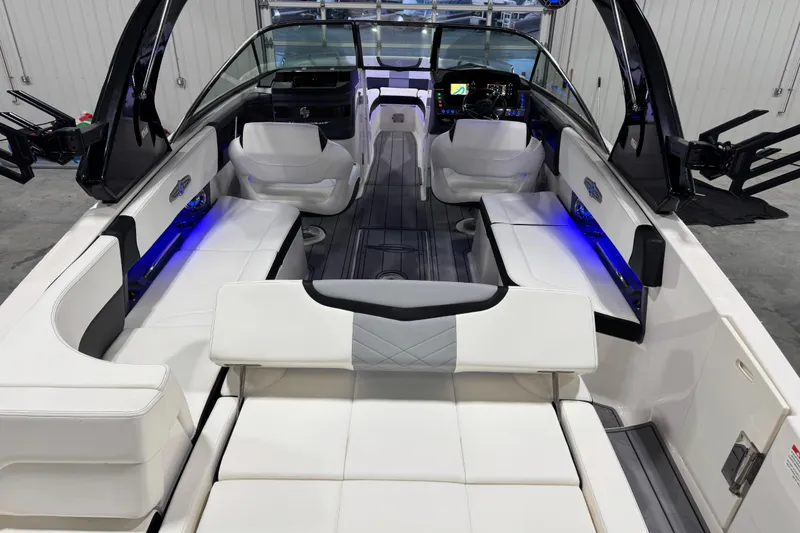 Slide: The Image of 2023 Chaparral 30 Surf boat interior with white seating and blue LED lighting. - 7