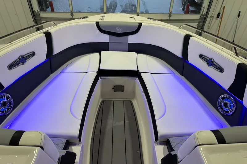 Slide: The Image of 2023 Chaparral 30 Surf boat interior with blue LED lighting and cushioned seating. - 8