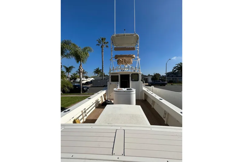 Slide: The Image of 2000 Parker 2520 XLD Sport Cabin boat with tower, docked under clear blue sky. - 10
