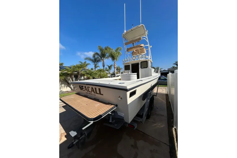 Slide: The Image of 2000 Parker 2520 XLD Sport Cabin boat in driveway, sunny day, palm trees. - 12