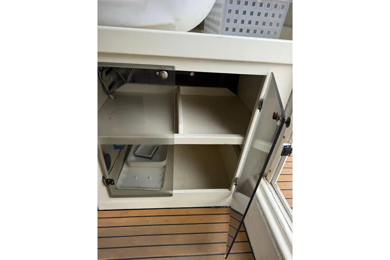 Slide: The Image of Open cabinet in 2000 Parker 2520 XLD Sport Cabin, showcasing interior storage space. - 28