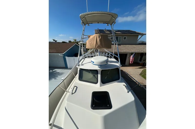 Slide: The Image of 2000 Parker 2520 XLD Sport Cabin boat with tower, parked in driveway. - 4