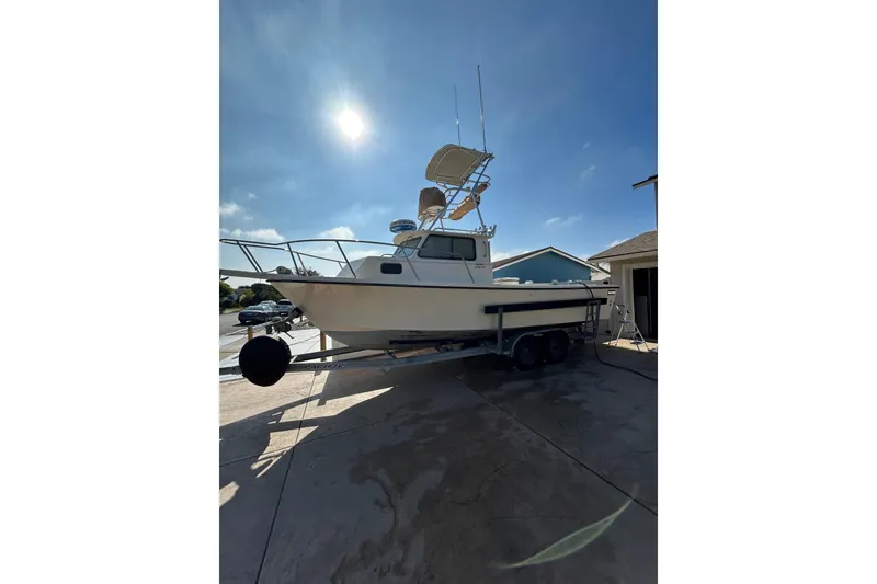 Slide: The Image of 2000 Parker 2520 XLD Sport Cabin boat on trailer under sunny sky. - 5