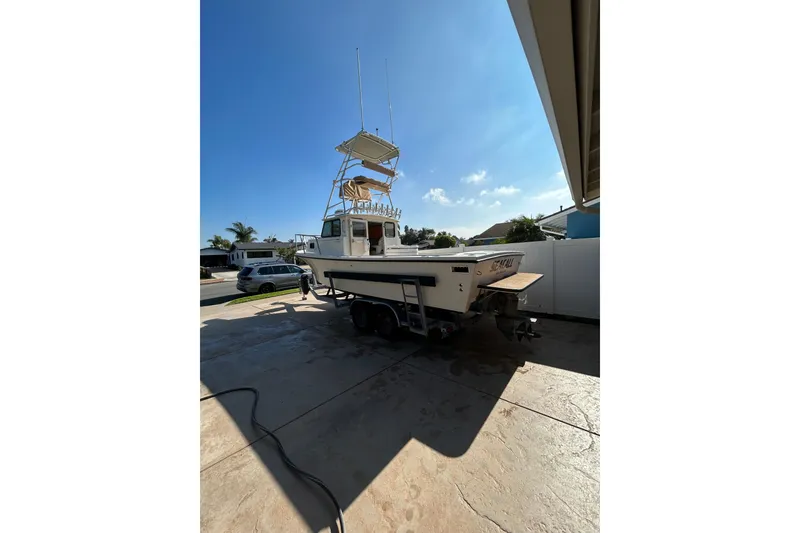 Slide: The Image of 2000 Parker 2520 XLD Sport Cabin boat on trailer in driveway under clear blue sky. - 6