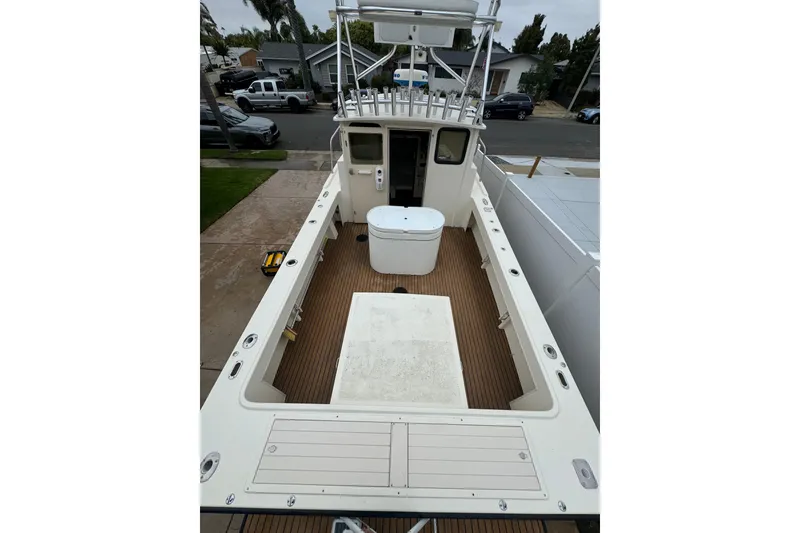 Slide: The Image of Parker 2520 XLD Sport Cabin 2000, spacious deck view, docked in residential area. - 9
